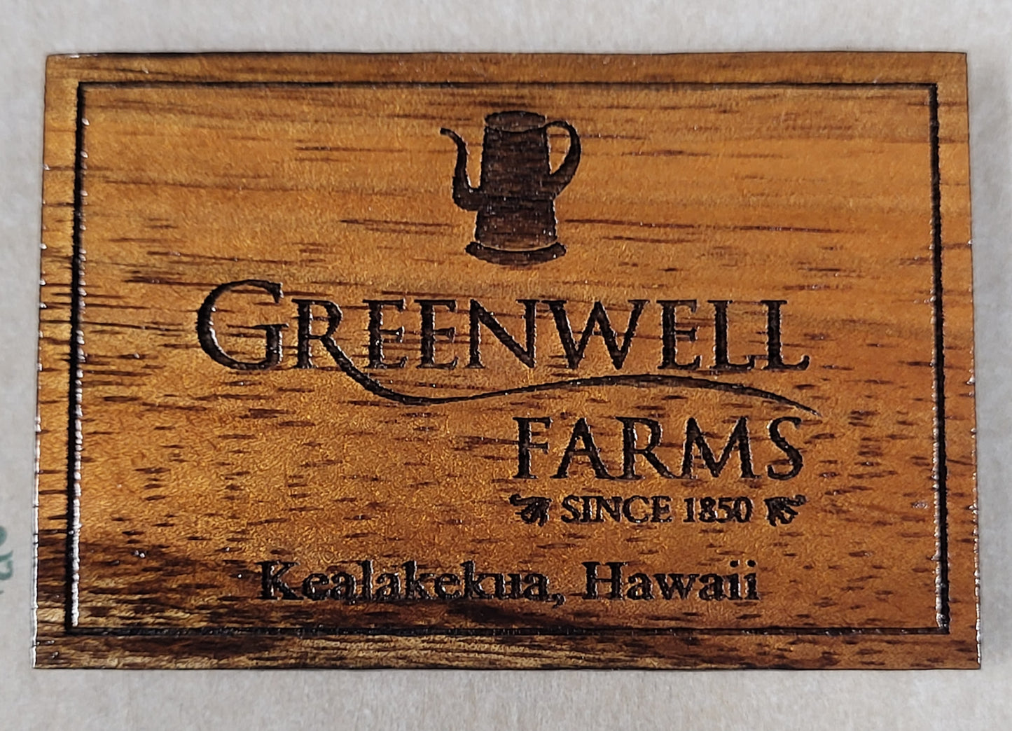 A wooden plaque featuring the engraved logo and text for Greenwell Farms