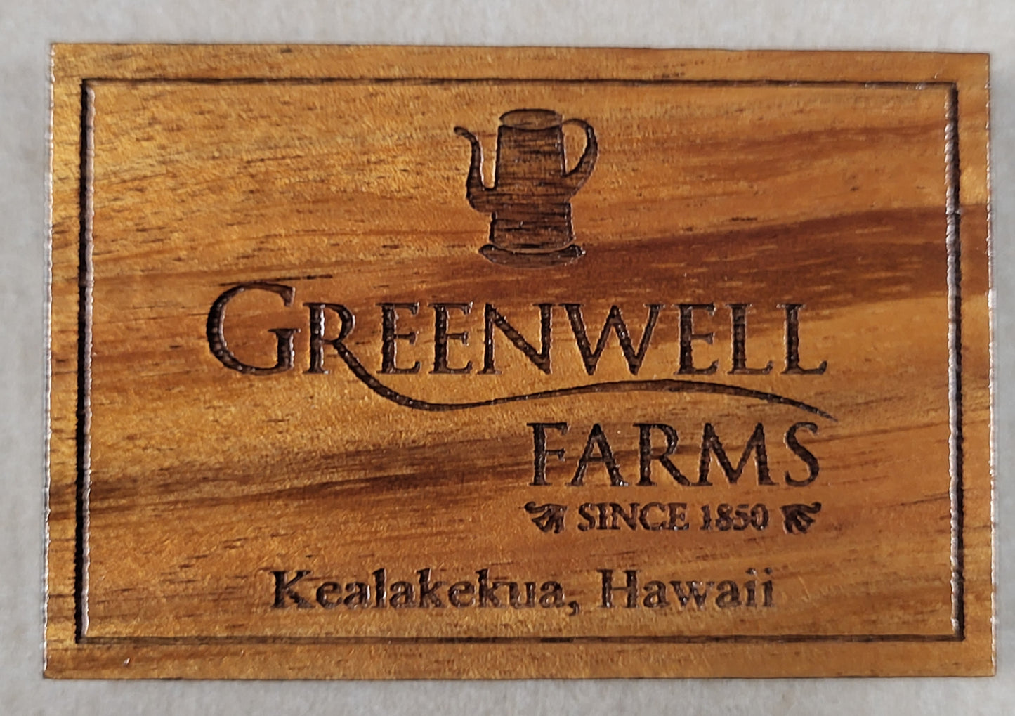 A wooden plaque featuring the engraved logo and text for Greenwell Farms